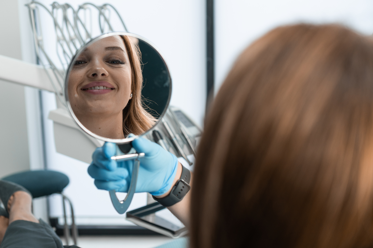 Patient checking smile during porcelain crown consultation
